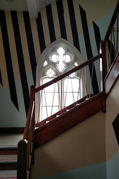 Angled dark stripes and light blue shapes on an ornate staircase.