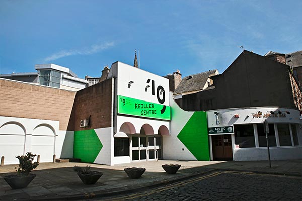 Exterior of the Keiller Centre in the sunshine with freshly painted white exterior, luminous green shapes and black branding for the Dundee Design Festival 2019.