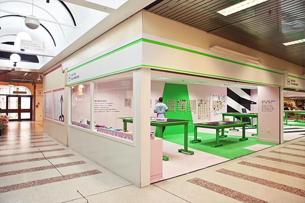 Vibrant space with a 1970s shopping centre. Lettering blocks line the walls with printing tables in the space.