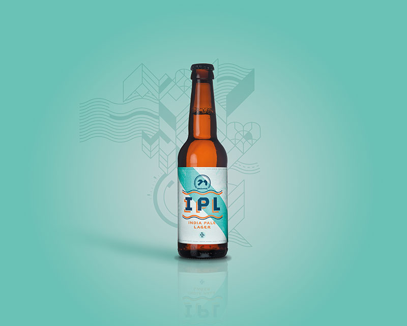 India Pale Lager bottle sits on turquoise background.