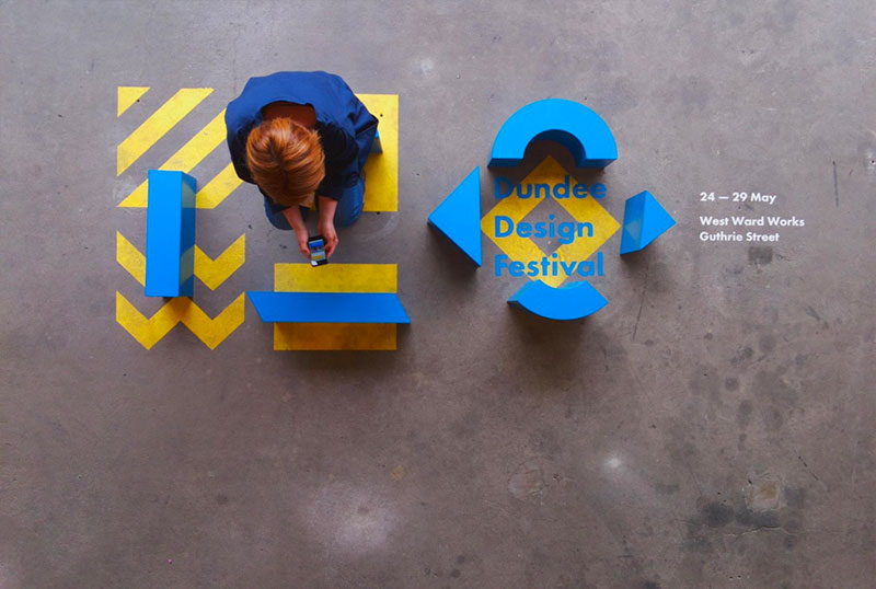 Woman sits on coloured blocks of Dundee Design Festival 2017 logo.