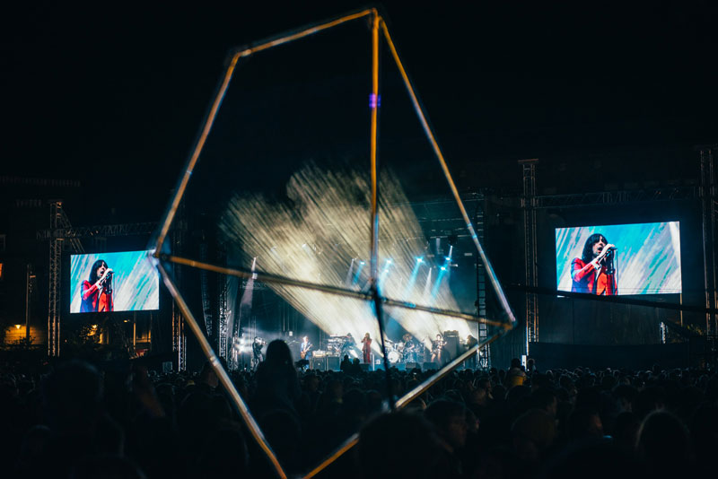 Giant illuminated shape in the crowd at a concert.